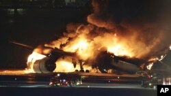 Avion Japan Erlajnza gori na pisti aerodroma Haneda u Tokiju (Foto: Kyodo News via AP)