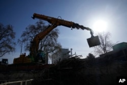 FILE - A bulldozer operates at a water storage tank construction site in Paris, Wednesday, April 5, 2023. (AP Photo/Christophe Ena)