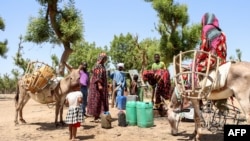 FILE: Women ride donkeys to fill their water cans at the only water well in the nomadic settlement of Toukra in N'Djamena, Chad, on June 10, 2022. - In Chad, many nomadic herders are settling down, discouraged by global warming, lack of access to pasture and community conflicts.