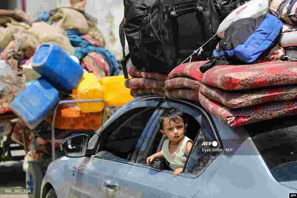 Seorang anak balita melihat dari jendela mobil yang penuh dengan barang-barang saat keluarganya dan warga Palestina lainnya mengungsi dari Deir el-Balah di Jalur Gaza tengah, di tengah konflik Israel dan kelompok militan Hamas. (AFP)&nbsp;