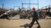 FILE - Employees of a critical power infrastructure installation, hit by a Russian missile strike, walk by its destroyed part, amid Russia's attacks on Ukraine, in Kharkiv, northeastern Ukraine, April 10, 2024.