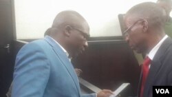 Transform Zimbabwe leader Jacob Ngarivhume talking to his attorney, Professor Lovemore Madhuku