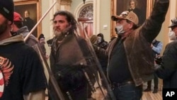 FILE - Rioters, including Dominic Pezzola, center with police shield, are confronted by U.S. Capitol Police officers in the Capitol in Washington, Jan. 6, 2021. Pezzola, a former member of the far-right Proud Boys group, was sentenced to 10 years in prison.