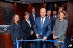 In this image provided by the White House, President Joe Biden stands in the reception area as he attends a ribbon cutting for the renovated White House Situation Room in the West Wing of the White House, Sept. 5, 2023.