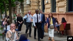 U.S. Deputy Treasury Secretary Wally Adeyemo, center, walks through downtown Kyiv during his official visit to Ukraine's capital, May 29, 2024.