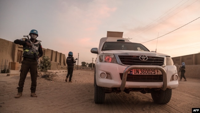 FILE - UN policemen escort an armored car of the United Nations Stabilization Mission in Mali (MINUSMA), during a patrol in Timbuktu, on Dec. 8, 2021.