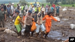 FILE - Rescuers carry the body of a victim of a flash flood in Tanah Datar, West Sumatra, Indonesia, on May 13, 2024.