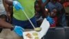 FILE - A server ladles soup into a container as children line up to receive food at a shelter for families displaced by gang violence, in Port-au-Prince, Haiti, March 14, 2024.