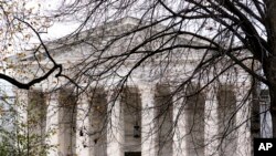 FILE - The Supreme Court is seen amid bare tree branches, on Capitol Hill in Washington, Dec. 7, 2023. 