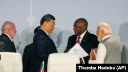 South African President Cyril Ramaphosa (2nd R) speaks to China's President Xi Jinping as President of Brazil Luiz Inacio Lula (L) and Prime Minister of India Narendra Modi look on, at the BRICS summit in Johannesburg, South Africa Aug. 24, 2023. (AP Photo/Themba Hadebe)