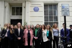 Guests pose for a photograph in front of the new unveiled plaque number 1,000 to honor the Women's Freedom League, in London, Sept. 19, 2023.