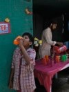 File - Seorang sukarelawan membagikan air minum di samping halte bus pada siang hari di musim panas yang terik di Hyderabad, India, 21 Maret 2024. (AP/Mahesh Kumar A., File)