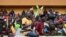 A man waves Niger, Mali and Burkina Faso flags as supporters cheer from the stands while artists perform during a concert in support to Niger's National Council for the Safeguard of the Homeland at General Seyni Kountche Stadium in Niamey, Aug. 13, 2023. 