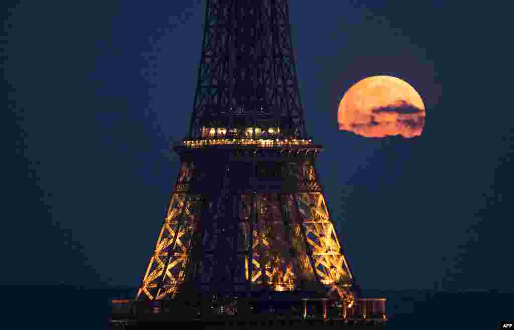 Bulan purnama di bulan April, juga dikenal sebagai Bulan Merah Muda, terlihat di belakang Menara Eiffel di Paris. (AFP)&nbsp;