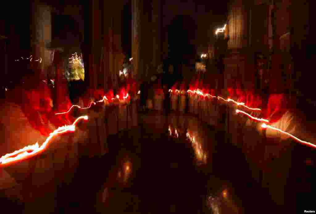 Para pelaku tobat memegang lilin mengikuti ritual pertobatan di dalam sebuah gereja sebagai rangkaian Pekan Suci Paskah di Ronda, Spanyol, Rabu, 27 Maret 2024.