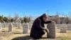 A survivor of the gas attack in Halabja in 1988, sits by the grave where he buried his entire family.