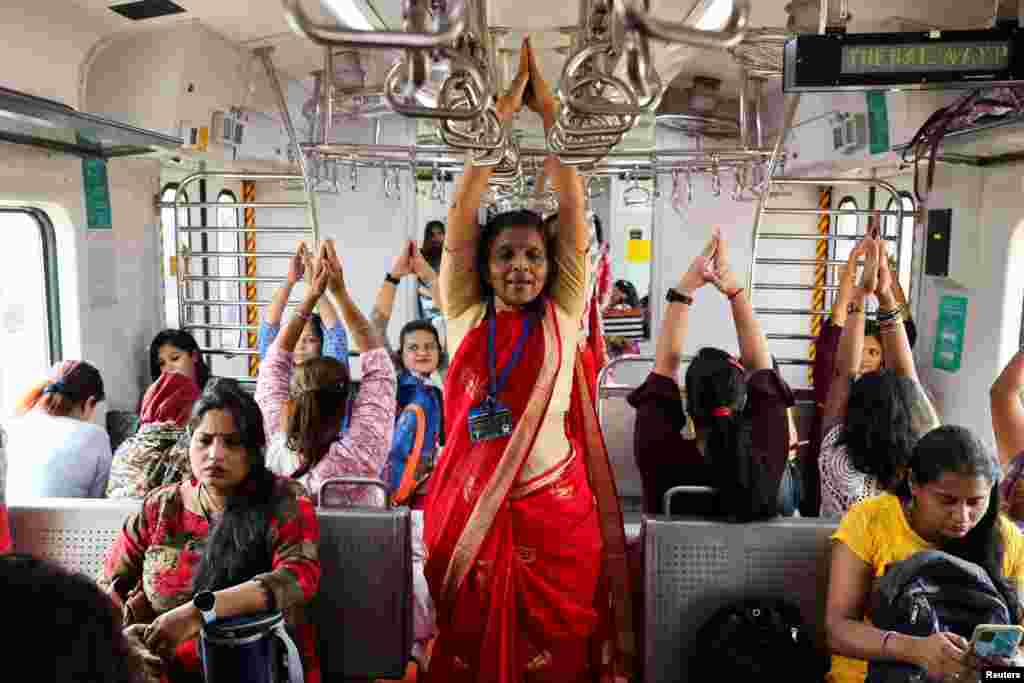 Women practice yoga in a local train on the occasion of International Women&#39;s Day in Mumbai, India.