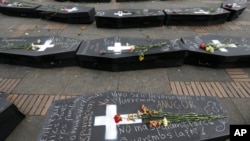 ARCHIVO - En esta fotografía de archivo del 9 de abril de 2018, flores sobre ataúdes simbólicos que representan a las víctimas del conflicto civil de Colombia en la plaza Bolívar en Bogotá, Colombia.