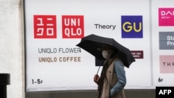FILE - A man walks in front of a Uniqlo store in Tokyo, April 13, 2023. The clothing giants is among those accused of allegedly profiting from forced labor rendered by members of the Uyghur minority in China.