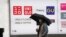FILE - A man walks in front of a Uniqlo store operated by Japan's Fast Retailing in Tokyo, April 13, 2023. 