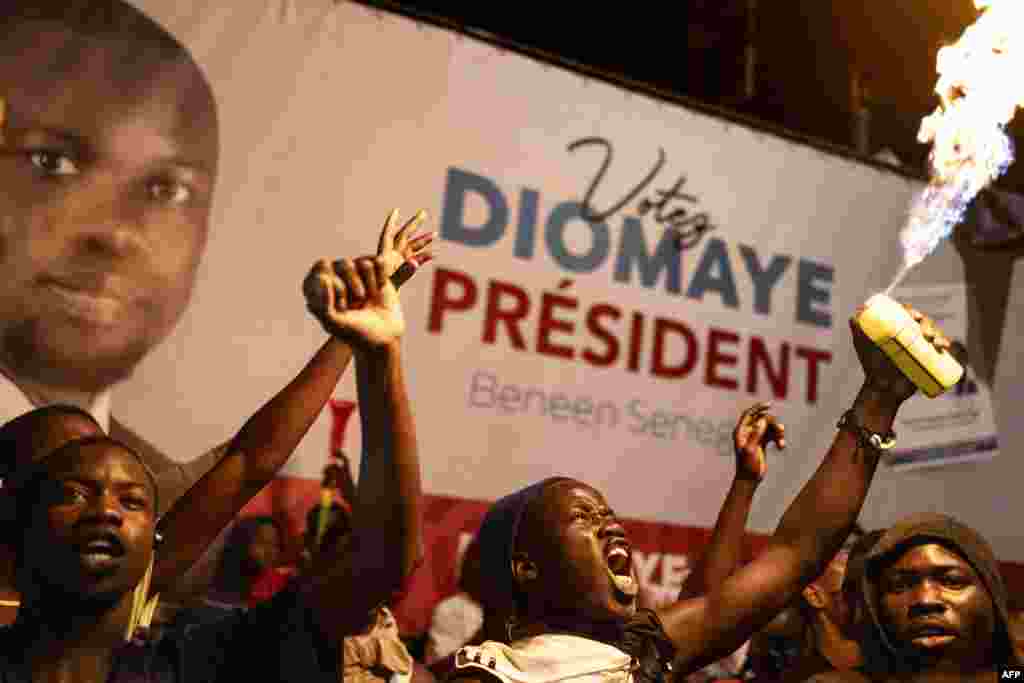 Apoiantes do candidato presidencial da oposição Bassirou Diomaye Faye e do líder da oposição Ousmane Sonko festejam na sede da coligação de Diomaye durante a contagem dos votos, em Liberte 4, Dakar, a 24 de março de 2024. &nbsp; 