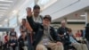 World War II Veteran Cletis Bailey waves as onlookers cheer and offer gratitude for him and a group of World War II Veterans traveling to Normandy, France to commemorate D-Day, in Atlanta, Georgia, June 2, 2024. 