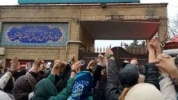 This grab taken from a UGC video made available on the ESN platform on March 4, 2023, shows families gathering and chanting slogans outside an education ministry building in Tehran, following poisoning attacks on students.