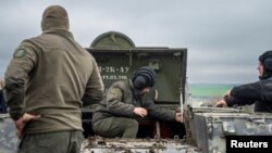 Prajurit berdiri di dekat kendaraan militer di posisi pertahanan, tempat Garda Nasional Ukraina bersiap mempertahankan Odesa, 10 April 2023. (Foto: via Reuters)