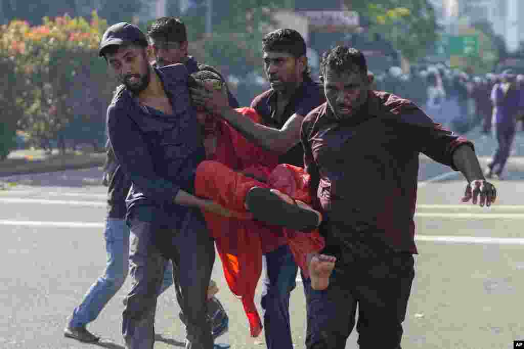 Members of Sri Lankan opposition political party National People&#39;s Power carry an injured Buddhist monk during a clash with police in Colombo.&nbsp;The opposition supporters were protesting over a decision to postpone local elections after the government said it cannot finance them because of the country&#39;s crippling economic crisis.