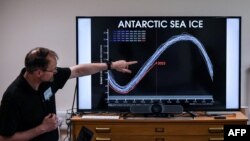 FILE - A professor of the British Antarctic Survey explains a graph on the state of Antarctic sea ice at different years, at the British Antarctic Survey's headquarters in Cambridge, June 19, 2023.