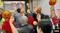 多名参与财政预算案直播会的香港基层市民，高举“嬲嬲”(不高兴)表情纸牌，对俗称“派糖”的纾困措施大幅“减甜”表达不满 (美国之音/汤惠芸)