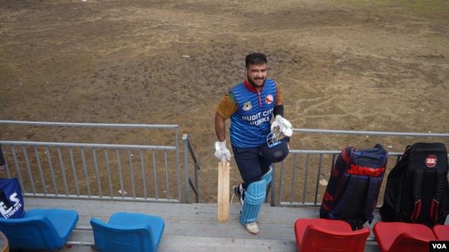Faisal Dar, a young cricketer from Srinagar on the Indian side of Kashmir, walks back to the pavilion after paying a quick knock. (VOA)
