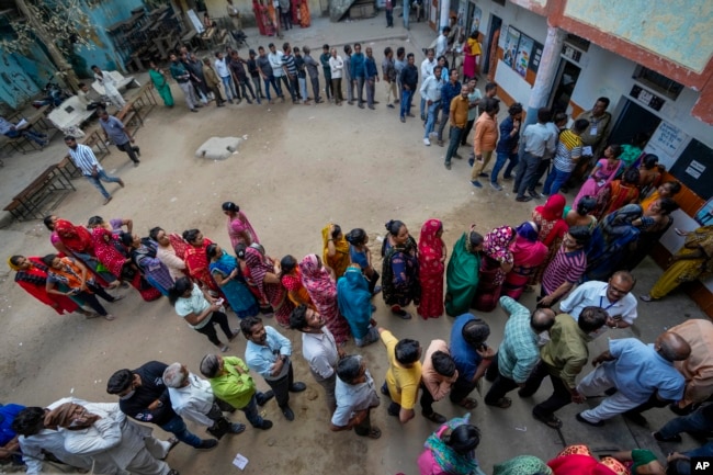 In this file photo, people stand in queue to cast their votes during the second phase of Gujarat state legislature elections in Ahmedabad, India, Monday, Dec. 5, 2022. (AP Photo/Ajit Solanki, File)