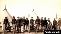 Artillery soldiers pose with Hotchkiss machine guns used against Lakota men, women and children in the 1890 Wounded Knee Massacre. 