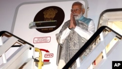 India's Prime Minister Narendra Modi gestures as he arrives at the Sydney international airport on May 22, 2023, to begin his three-day visit to Australia. 