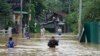 People wade through flood waters in Kelaniya, a suburb of Colombo, Sri Lanka, June 3, 2024.