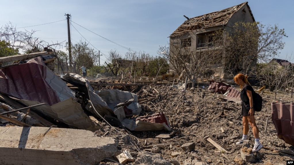 A woman looks at a crater following an air attack in the Odesa region of Ukraine, on Aug. 26, 2024.