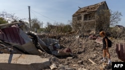 A woman looks at a crater following an air attack in the Odesa region of Ukraine, on Aug. 26, 2024.