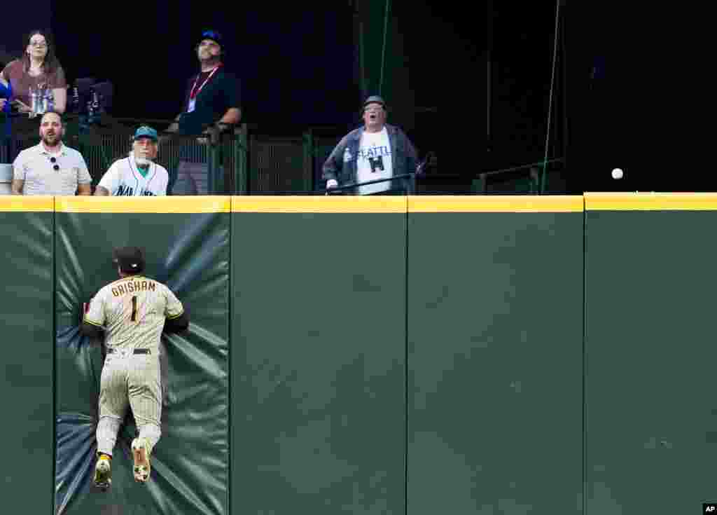 San Diego Padres center fielder Trent Grisham hits the wall as the triple base hit from Seattle Mariners&#39; Dylan Moore rolls along the top of the wall during the sixth inning of a baseball game on August 8, 2023, in Seattle, Washington.&nbsp;
