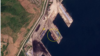 북한 라진항을 촬영한 25일 자 위성사진에서 대형 선박과 컨테이너(원 안)를 볼 수 있다. 바로 옆 부두에서도 컨테이너 추정 물체(화살표)가 확인된다. 사진=Planet Labs