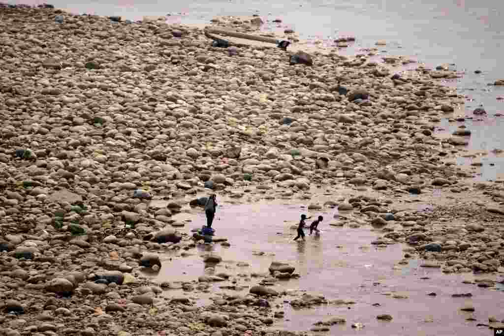 Boys try to cool off in the River Tawi on a hot summer day in Jammu, India.