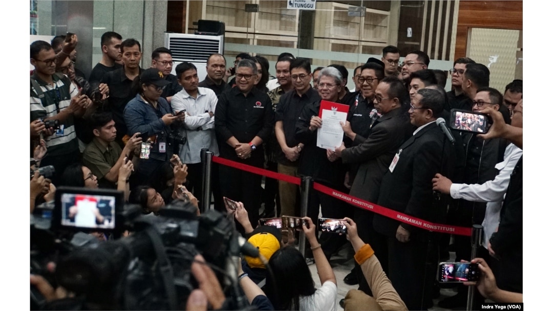 Ketua Tim Kuasa Hukum Paslon Nomor 02, Todung Mulya Lubis (tengah) memberikan keterangan kepada wartawan usai pendaftaran perkara Pemilu Presiden 2024 pada Sabtu (23/3) di Gedung MK, Jakarta. (VOA/IndraYoga)