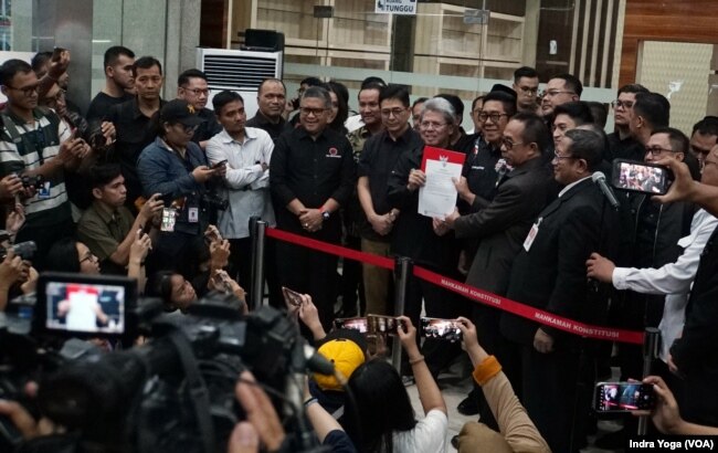 Ketua Tim Kuasa Hukum Paslon Nomor 02, Todung Mulya Lubis (tengah) memberikan keterangan kepada wartawan usai pendaftaran perkara Pemilu Presiden 2024 pada Sabtu (23/3) di Gedung MK, Jakarta. (VOA/IndraYoga)