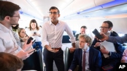 Britain's Prime Minister Rishi Sunak speaks with members of the media onboard his plane bound for San Diego, California, March 12, 2023, to meet with U.S. President Joe Biden and Prime Minister of Australia Anthony Albanese.
