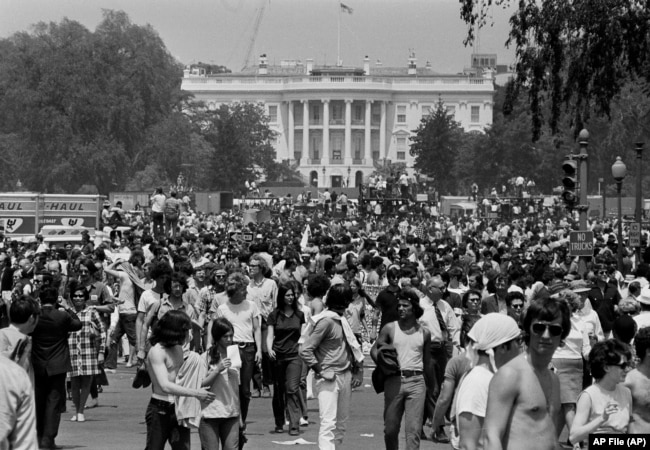 FILE - Anti-war demonstrators raise their hands toward the White House as they protest the shootings at Kent State University and the U.S. incursion into Cambodia, on the Ellipse in Washington D.C., on May 9, 1970. (AP File Photo)