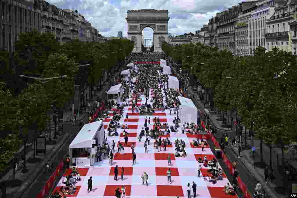 People take part in a giant open-air picnic on the Champs-Elysees avenue in Paris, France.