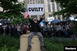 A man holds a placard outside Manhattan Criminal Court following the verdict in former U.S. President Donald Trump's criminal trial over charges that he falsified business records, in New York City, May 30, 2024.