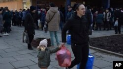 People receive food at a humanitarian aid distribution spot in Zaporizhzhia, Ukraine, March 9, 2023.