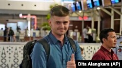 Warga negara Australia Bodhi Mani Risby-Jones dari Queensland mengacungkan jempol saat menunggu check in di Bandara Internasional Soekarno-Hatta di Tangerang, Sabtu, 10 Juni 2023. (AP/Dita Alangkara)