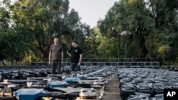 Mykhailo Fedorov, Ukrainian minister of digital transformation, right, and Yuriy Shchygol, head of State Special Communications Service, stand next to drones that are being sent to the frontline, in Kyiv, Ukraine, July 25, 2023.